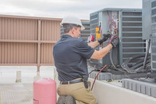 HVAC technician servicing commercial rooftop AC units in South Jersey